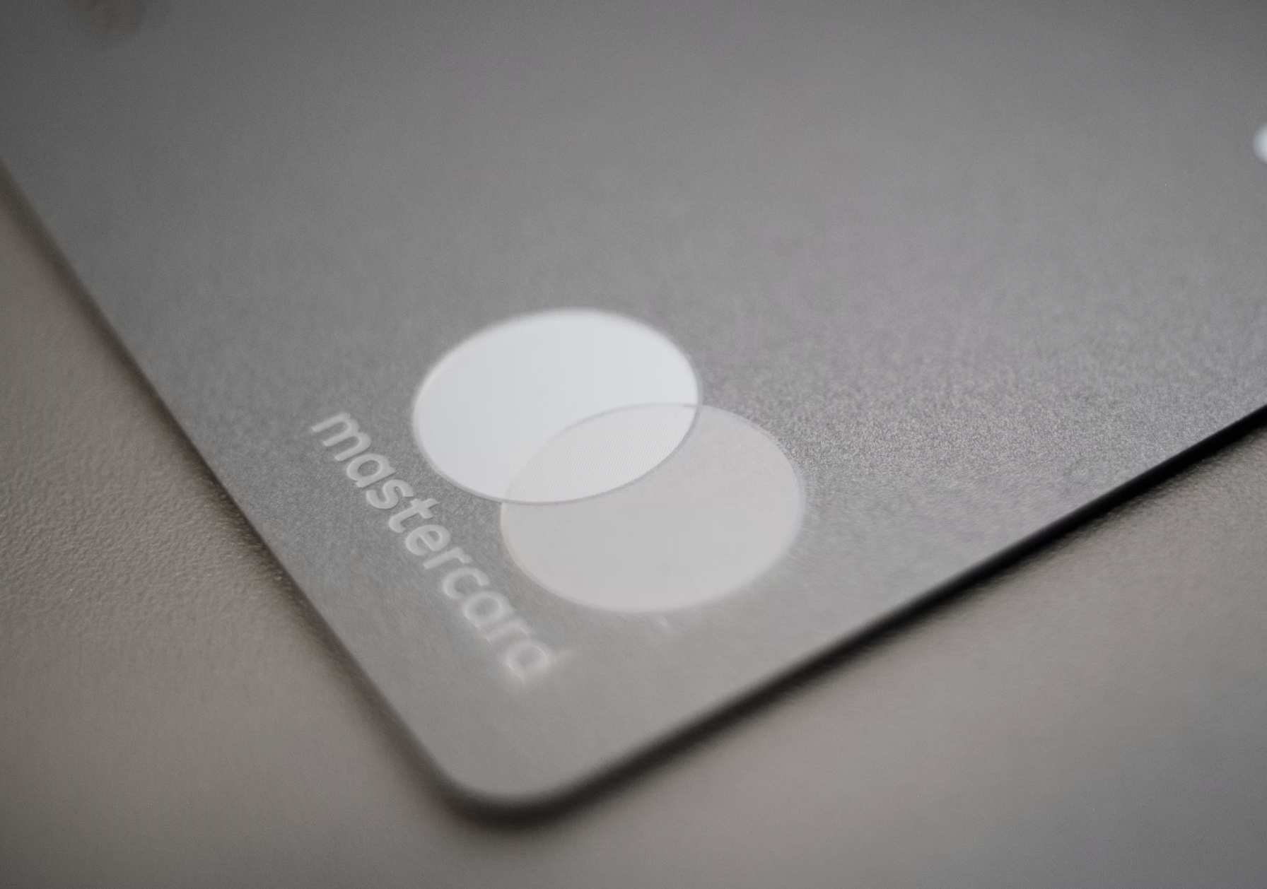 Close-up of a gray laptop touchpad with two overlapping circular buttons and the word 'mastercard' along the edge.